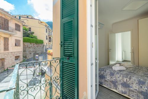 Habitación con balcón, cama y puerta. en il giardino di Riomaggiore, en Riomaggiore
