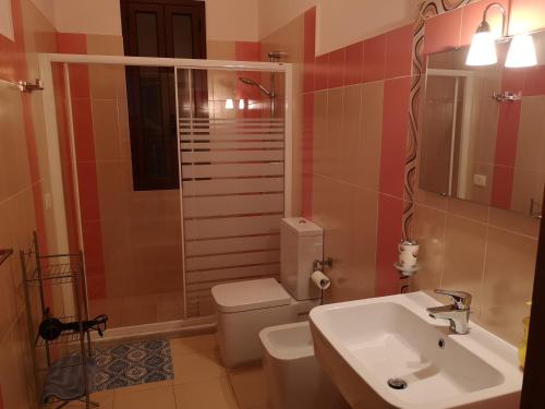 a bathroom with a white toilet and a sink at B&B AMURI RANNI in Avola