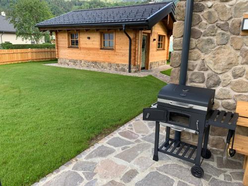 a barbecue grill in front of a house at Chalet Hoamatgfühl mit Gartensauna - in der Nähe von Schladming in Haus im Ennstal