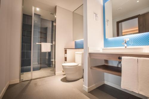 Un baño con inodoro, lavabo y ducha. en Holiday Inn Express Guizhou Qinglong by IHG, en Qinglong