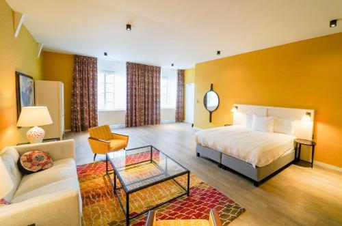 a hotel room with a bed and a couch at Fletcher Hotel-Restaurant De Oude Gevangenis-Alkmaar in Alkmaar