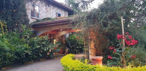 a house with an archway in a garden at La Mada Hotel in Nairobi