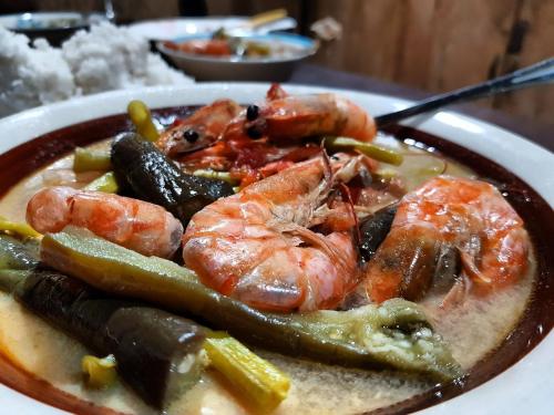 a plate of food with shrimp and vegetables on a table at Playa Encantada Beach Resort in El Nido