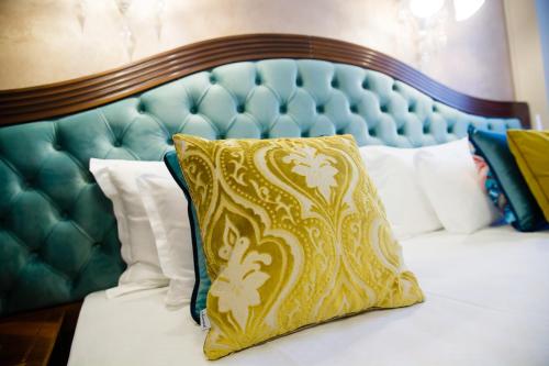 a bed with a green headboard with a yellow pillow at Grand Hotel Traian in Iaşi