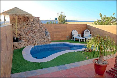 - une piscine dans une cour avec une table et des chaises dans l'établissement Chalet acogedor con piscina, à Conil de la Frontera