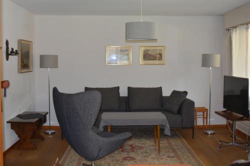 ein Wohnzimmer mit einem Sofa und einem Stuhl in der Unterkunft Apartment Champéry Grand Pré A in Champéry