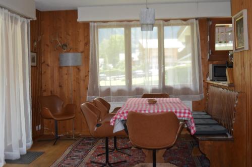 ein Esszimmer mit einem Tisch, Stühlen und einem Fenster in der Unterkunft Apartment Champéry Grand Pré A in Champéry