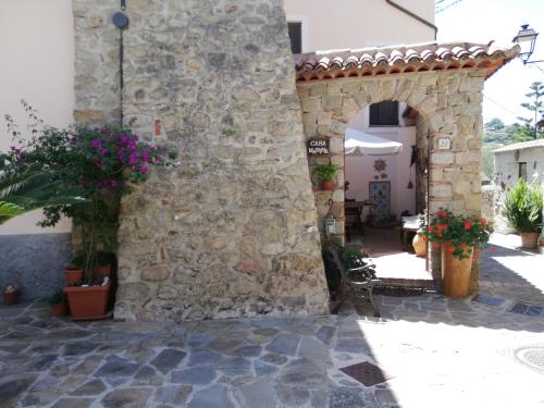 an entrance to a stone building with an arch and flowers at Casa Marina, Cilento Appartamento Indipendente in Ceraso