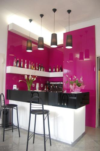 a bar with pink walls and chairs in a room at HOTEL ALBA in Montecatini Terme