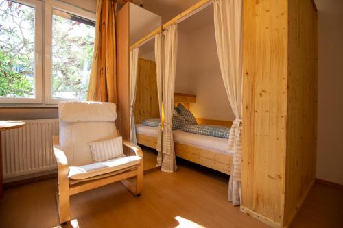 a bedroom with a bed and a chair and a window at Haus Kinspergher in Innsbruck