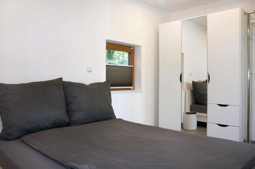 1 dormitorio con cama, ventana y espejo en Cube-House Ferienhaus in Franken en Volkach