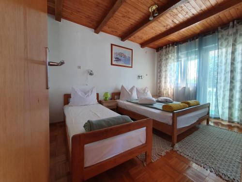 sypialnia z dwoma łóżkami i oknem w obiekcie Apartman Lu w mieście Vir
