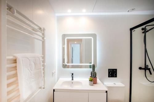 a white bathroom with a sink and a mirror at NC Apartments Rambla 32 in Figueres