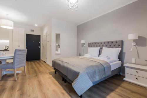 a bedroom with a bed and a desk and a chair at Symphony Baltica Towers Apartamenty in Gdańsk