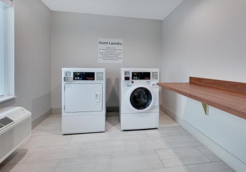 two washing machines and a washer and dryer in a room at Holiday Inn Express & Suites San Antonio NW near SeaWorld by IHG in San Antonio