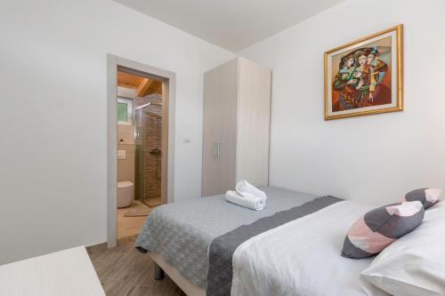 a bedroom with two beds and a painting on the wall at House Bumbiste 1703 in Banjole