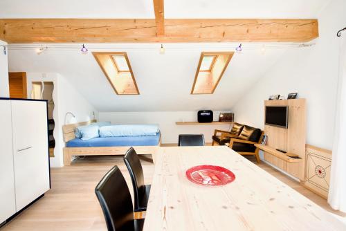 Cette chambre comprend une table avec des chaises et un lit. dans l'établissement Terra Berni, à Vals