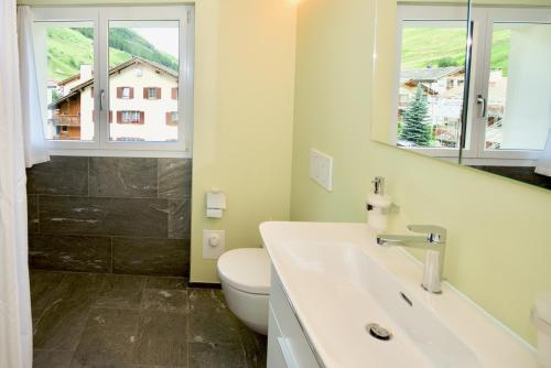 ein Bad mit einem Waschbecken, einem WC und einem Fenster in der Unterkunft Terra Berni in Vals