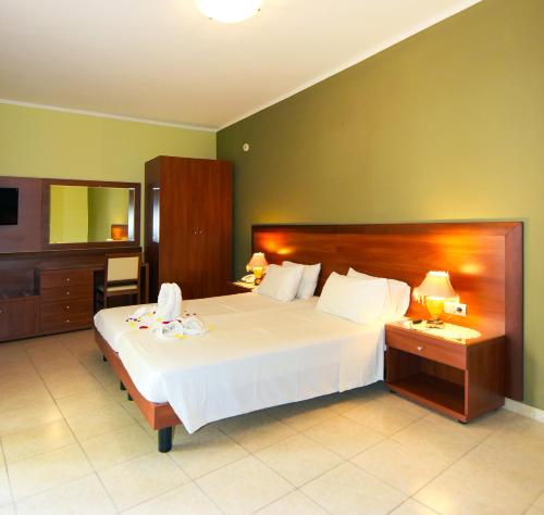 クレマスティにあるEsmeralda Hotelのベッドルーム(大きな白いベッド1台、鏡付)
