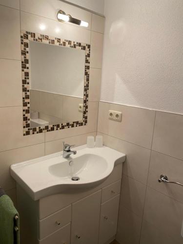 ein Badezimmer mit einem weißen Waschbecken und einem Spiegel in der Unterkunft Berggasthof Bayernturm in Zimmerau
