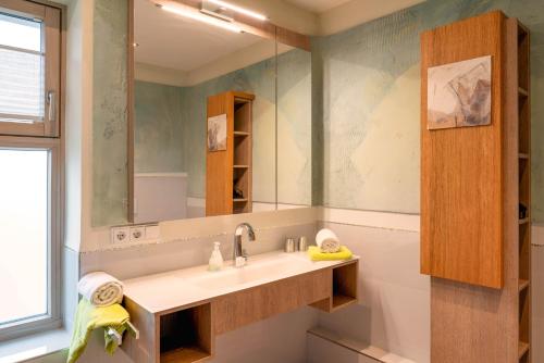 a bathroom with a sink and a mirror at Lebensart am See in Bad Endorf