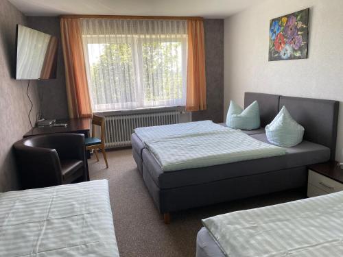 ein Hotelzimmer mit 2 Betten, einem Schreibtisch und einem Stuhl in der Unterkunft Berggasthof Bayernturm in Zimmerau