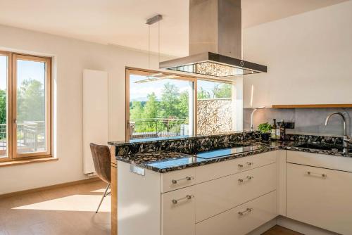 a kitchen with a sink and a large window at Lebensart am See in Bad Endorf