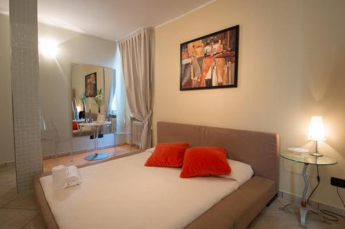 a room with a bed with two orange pillows on it at Relais Corte Bergamini in Peschiera del Garda