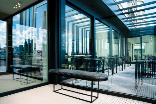 a row of tables and chairs in a building with windows at Hotel du Bassin in Ostend