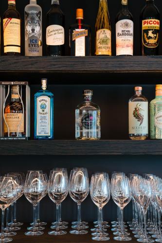 a row of wine glasses on a shelf with bottles at Hotel du Bassin in Ostend