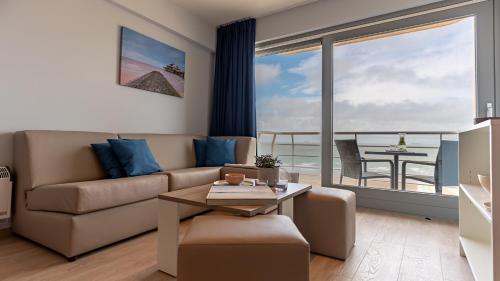 a living room with a couch and a table at Holiday Suites Blankenberge in Blankenberge