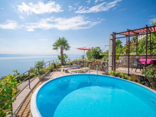 a swimming pool on the balcony of a house with the ocean at Holiday Home Villa More by Interhome in Lovran