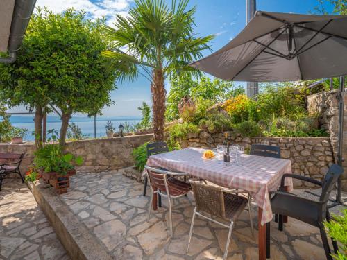 a patio with a table and chairs and an umbrella at Holiday Home Villa More by Interhome in Lovran