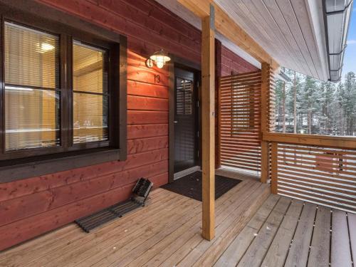 a front porch of a wooden cabin with windows at Holiday Home Sointuilevi 2 d 13 by Interhome in Levi