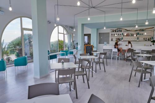 um restaurante com mesas e cadeiras e pessoas ao fundo em Il Varo a Mare em Punta Braccetto