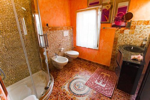 a bathroom with a shower and a toilet and a sink at Eden Lilli B&B in La Pieve