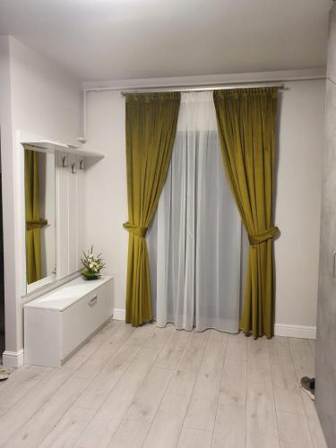a living room with yellow curtains and a dresser at Apartament Ozon Poiana Brasov in Poiana Brasov