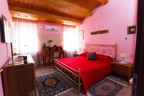 a bedroom with a bed with a red bedspread at Eden Lilli B&B in La Pieve