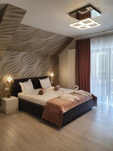 a bedroom with a large bed and a large window at Apartament Ozon Poiana Brasov in Poiana Brasov