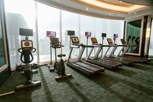 a gym with rows of exercise equipment in a building at Grande Centre Point Sukhumvit 55 Thong Lo in Bangkok