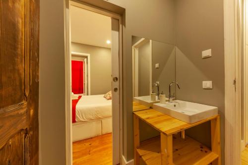 uma casa de banho com um lavatório e um espelho em The Bridge em Lisboa