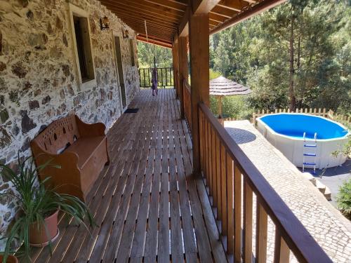 un porche de una casa con piscina en Casa Velha en Figueiró dos Vinhos