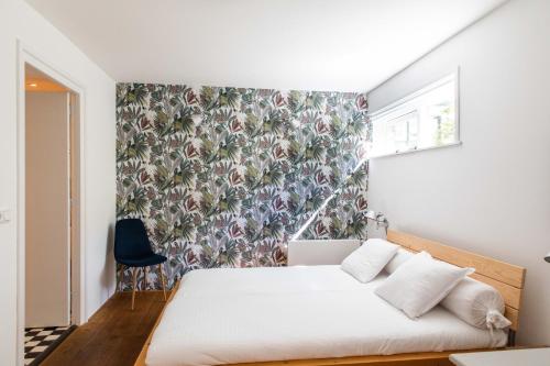 Un dormitorio con una cama con papel pintado floral. en Villa 1913, en Bergen