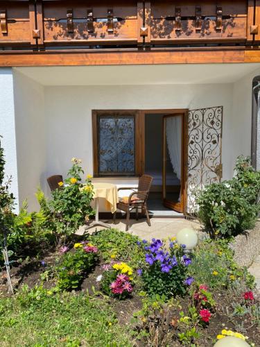 un patio de una casa con flores en el patio en Hotel Haus Seehang en Constanza