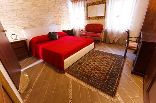 a bedroom with a red bed and a chair at Eden Lilli B&B in La Pieve
