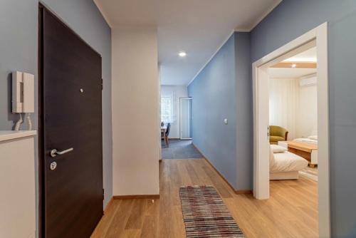 a hallway with a black door and a living room at Apartman Danube lux in Novi Sad