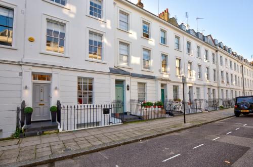 a row of white houses on a street at Victoria Belgravia Apartments in London