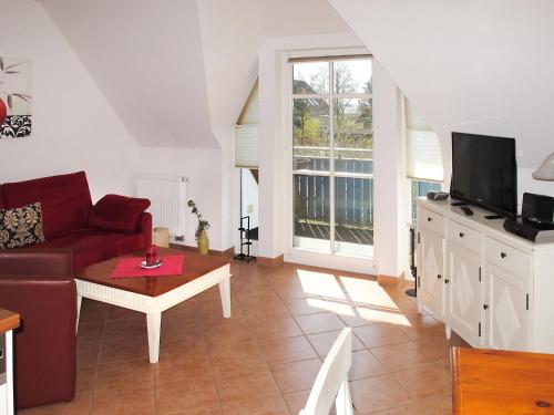 a living room with a couch and a tv at Apartment am Haferland by Interhome in Wieck