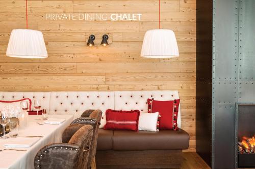 a dining room with a table with a couch and a fireplace at Infinity Hotel & Conference Resort Munich in Unterschleißheim