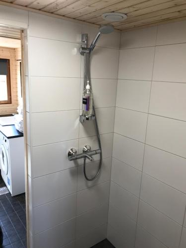 a shower with a shower head on a wall at Apartment Rentun Maja in Saariselka